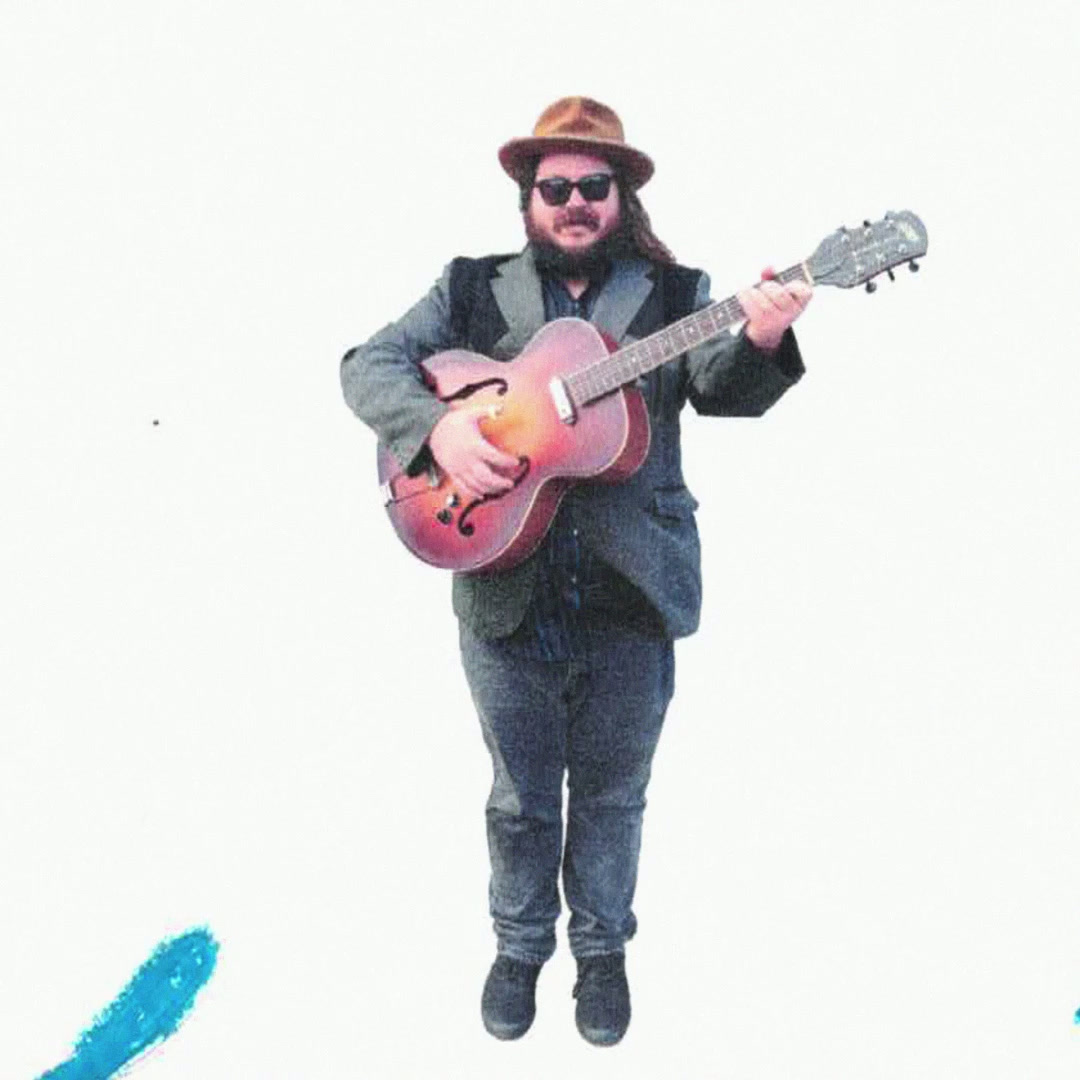 Tyler Westcott holding a hollow-body guitar